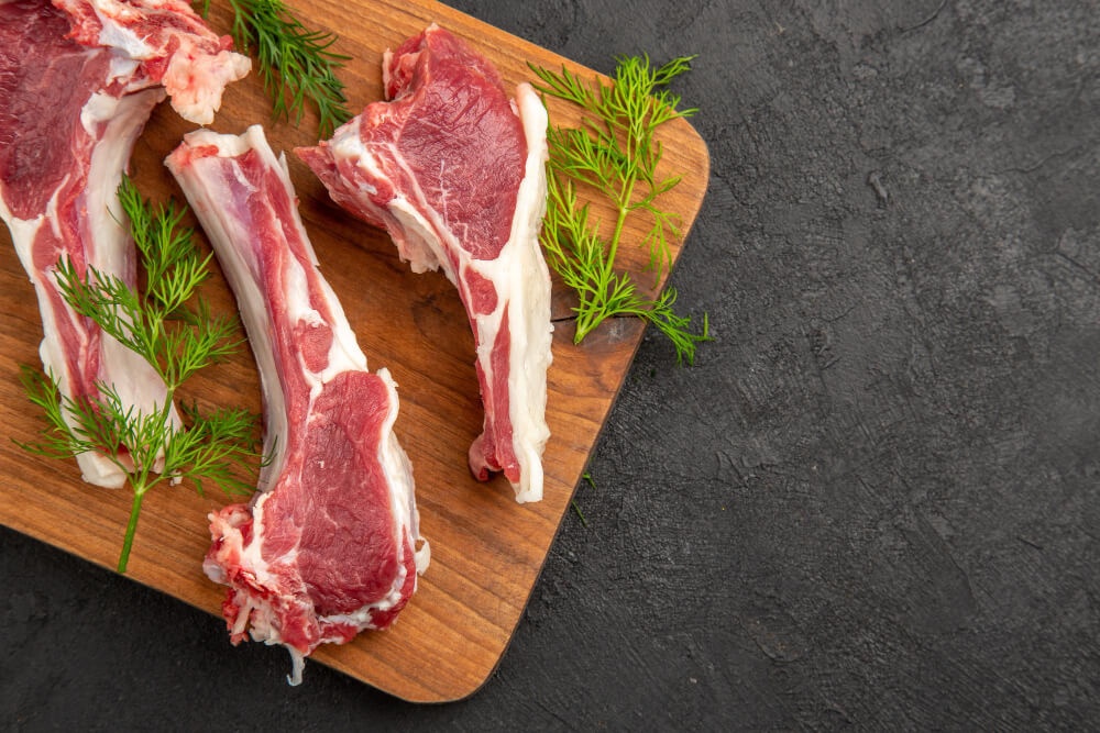 Fresh lamb chops on a wooden cutting board