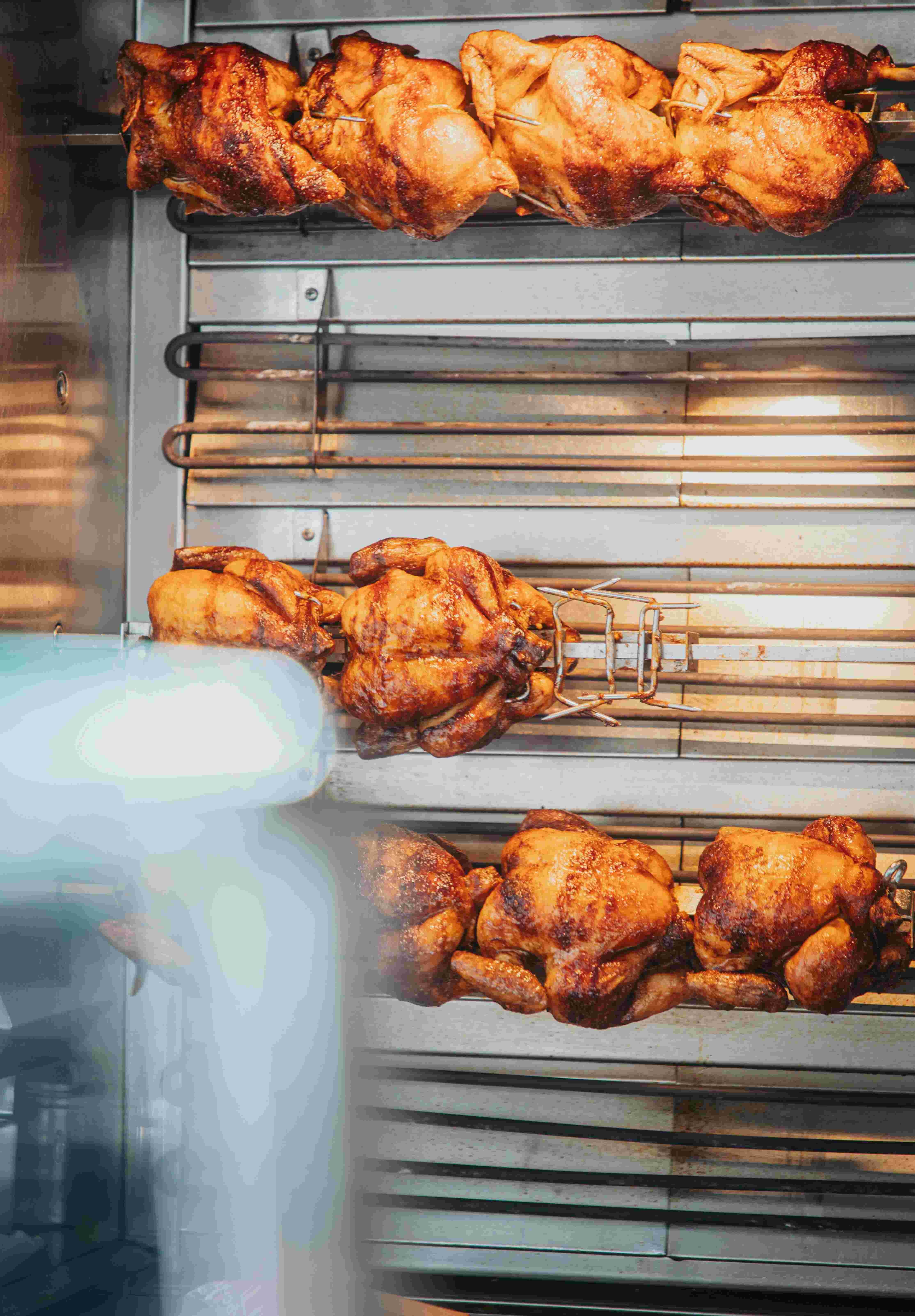 Golden rotisserie chickens slow-roasted to perfection